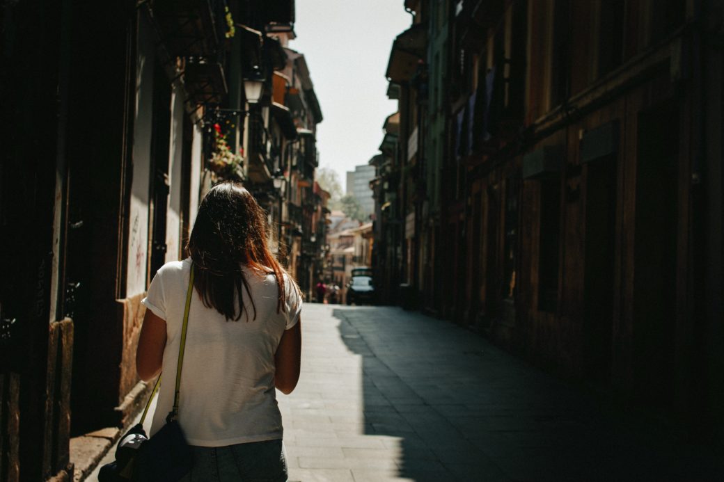 woman walking away on city street