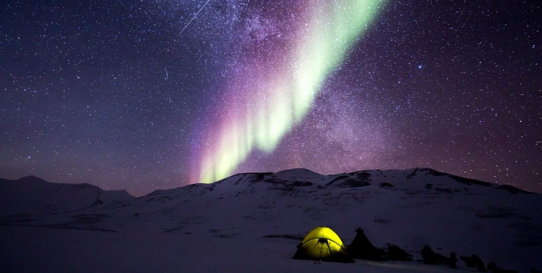 camping tent lit up on a peaceful night full of stars